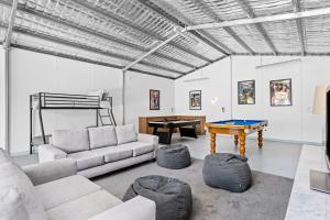 a living room with a couch and a ping pong table at Bayside Retreat - Cosy Fire Beach Games Room in McCrae