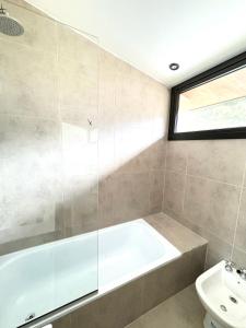 a bathroom with a tub and a toilet at Cantera Tempo 2 in Esquel