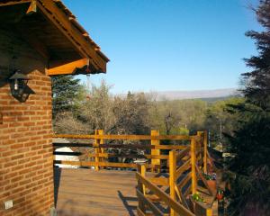 een houten terras met een hek en uitzicht bij El Chañar in Villa General Belgrano