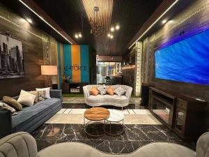 a living room with couches and a large screen tv at Casa Catorce Loft in Parras de la Fuente