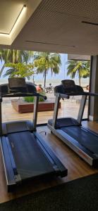 two treadmills in a gym with palm trees in the background at Unity 415 in João Pessoa