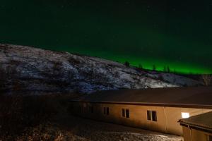 an image of the aurora borealis over a building at Hotel Studlagil in Skjöldólfsstaðir