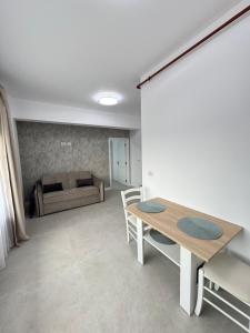 una sala de estar con una mesa y un sofá en DE Apartment, en Rădăuţi