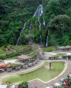 a waterfall in the middle of a park with a pond at El refugio santarrosano in Santa Rosa de Cabal