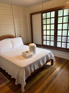 a bedroom with a bed with a stack of books at Costa Montana in Louro Müller