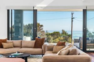 a living room with couches and a view of the ocean at Beachfront Luxury - Panoramic Views Games Wineries in Safety Beach +33 photos
