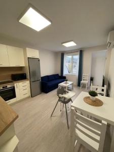 a kitchen and living room with a blue couch at Well Equipped New Family Friendly One-Bedroom Flat in Sandanski