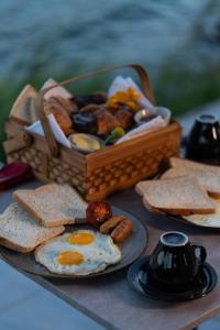 a table topped with a basket of eggs and toast at Inap Retreat Boutique Cabin Kintamani in Kubupenlokan +42 photos