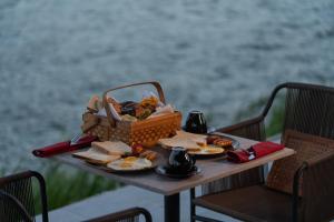 a picnic table with a basket of food and bread at Inap Retreat Boutique Cabin Kintamani in Kubupenlokan