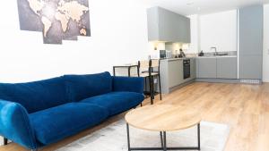 Una sala de estar con un sofá azul y una mesa. en Luxe Apartment in M1 with Pool, Gym & Spa, en Mánchester