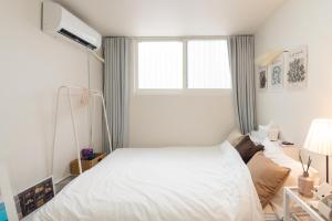 a bedroom with a white bed and a window at 스타폴스테이 in Seoul