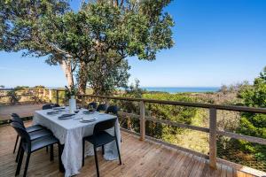 een eettafel op een terras met uitzicht op de oceaan bij Cleversley Cottage - Ocean Views Pets Golf in Flinders