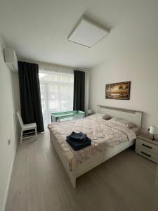 a bedroom with a bed and a table in it at Well Equipped New Family Friendly One-Bedroom Flat in Sandanski