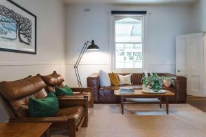 雷德山The Sunday School - Timeless Cottage Wine Region的配有皮沙发和桌子的客厅