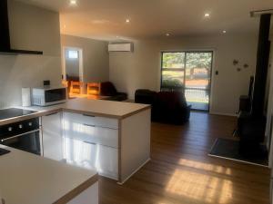 a kitchen and living room with a stove and a microwave at Time Out On Glenbrook in Twizel