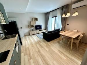 a living room with a table and a dining room at Beatiful titlhalo apartment in Nai Yang Beach