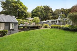 a backyard with a house and a lawn at Hillside Cottage - Wineries Pool in Red Hill South
