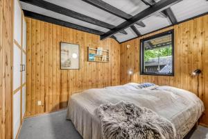 海默特C11249-Hemmet-Raevekrogen-88的一间带床的卧室，位于一间带木墙的房间里