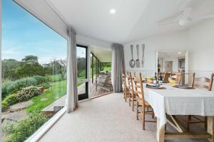 a dining room with a table and a large window at Coast n' Country - Bay Views Pool Games in Red Hill South