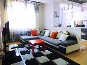 a living room with a couch and a table at Bishkek Flatlux Apartments in Bishkek