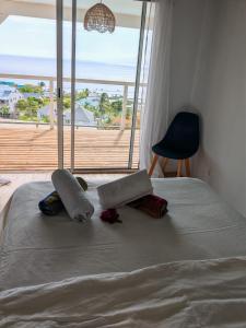 Una cama con dos almohadas y una ventana. en Villa MourAmour, en Saint-Leu