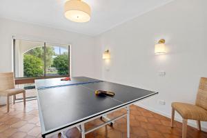 una mesa de ping pong en una habitación con sillas en Bayview Retro - Garden Patio Games Beach, en Mount Martha