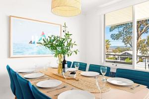 Un comedor con una mesa y sillas azules. en The Beach Getaway - Spa Table Tennis Soccer, en Safety Beach