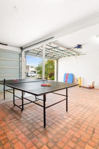una mesa de ping pong en medio de una habitación en The Beach Getaway - Spa Table Tennis Soccer, en Safety Beach