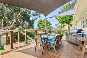 Un patio con mesa y sillas y parrilla. en The Beach Getaway - Spa Table Tennis Soccer, en Safety Beach