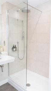 Una ducha con puerta de cristal junto al lavabo en Luxe Apartment in M1 with Pool, Gym & Spa, en Mánchester