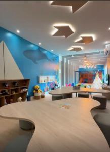 ein Kinderzimmer mit blauen Wänden und einem Tisch und Stühlen in der Unterkunft Prainha Sand Beach Arraial do Cabo in Arraial do Cabo