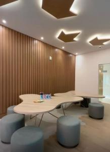 ein Besprechungsraum mit zwei Tischen und blauen Hockern in der Unterkunft Prainha Sand Beach Arraial do Cabo in Arraial do Cabo