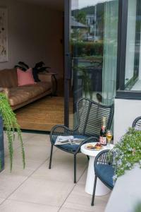 un patio con 2 sillas, una mesa y un sofá en Waterside Luxe - Marina Terrace, en Safety Beach 10 fotos más