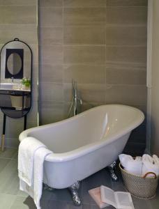 a white bath tub in a bathroom with a mirror at Le Général d'Elbée Hotel & Spa - Teritoria in Noirmoutier-en-l'lle