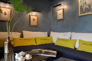 a blue couch with yellow pillows and a table at Le Général d'Elbée Hotel & Spa - Teritoria in Noirmoutier-en-l'lle