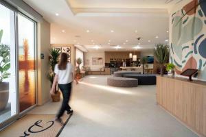 a woman is riding a skateboard in a lobby at Drifter Byron Bay in Byron Bay +79 photos