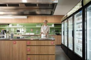 a woman standing behind a counter in a kitchen at Drifter Byron Bay in Byron Bay