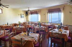 a dining room with tables and chairs with flowers on them at B&B Casa Bellavista in Castelmola