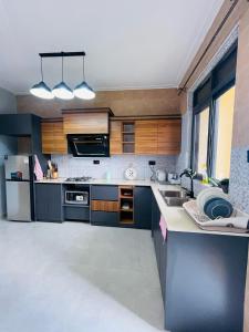 a kitchen with a sink and a refrigerator at Muyenga Tank Hill Apartments in Kampala