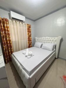 a bedroom with a large white bed with glasses on it at Grace Abode Haven in General Santos