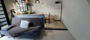 a living room with a blue couch and a kitchen at Casa aconchegante privativa in Limeira +8 photos