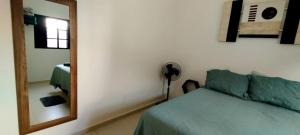 a bedroom with a green couch and a mirror at Casa aconchegante privativa in Limeira