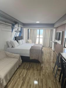 a hotel room with two beds and a television at Suite vista mar marinas cabo branco in João Pessoa +26 photos