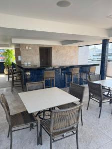 a restaurant with tables and chairs and a bar at Suite vista mar marinas cabo branco in João Pessoa