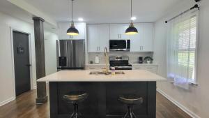 a kitchen with a large island with two bar stools at Entire house in Old Town Lilburn 4 bedrooms 4 bath in Lilburn +11 photos