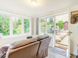 a living room with a couch and windows at Benchmark Cottage in Glaisdale