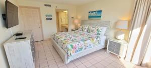 a bedroom with a bed and a dresser and a mirror at Beachfront Resort with Heated Pool Saida Royale 9039 in South Padre Island