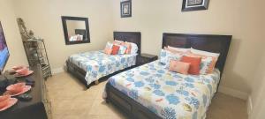 a bedroom with two beds and a mirror at Sapphire 1706 home in South Padre Island