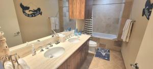 a bathroom with two sinks and a large mirror at Sapphire 1706 home in South Padre Island