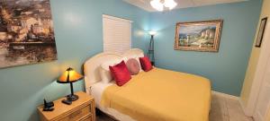 Un dormitorio con una cama con almohadas rojas. en Habitat #23 home, en South Padre Island